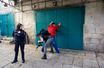 Un policier israélien fouille un palestinien après l'attaque du garde-frontière.