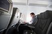 Un homme est connecté au wifi dans l'avion