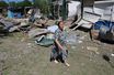Une femme passe devant des structures détruites sur un marché local à Donetsk, Ukraine le 19 juin 2022.