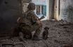 Un militaire ukrainien avec un chien dans la zone industrielle de la ville de Sievierodonetsk, en Ukraine, le 20 juin 2022.