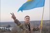 Un soldat ukrainien brandit le drapeau de son pays dans les faubourgs de Kherson.