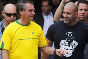 Bolsonaro a revêtu un maillot de l'équipe nationale brésilienne où il compte de nombreux supporters. A ses côtés, un proche a opté pour un tee-shirt moins pacifique. 