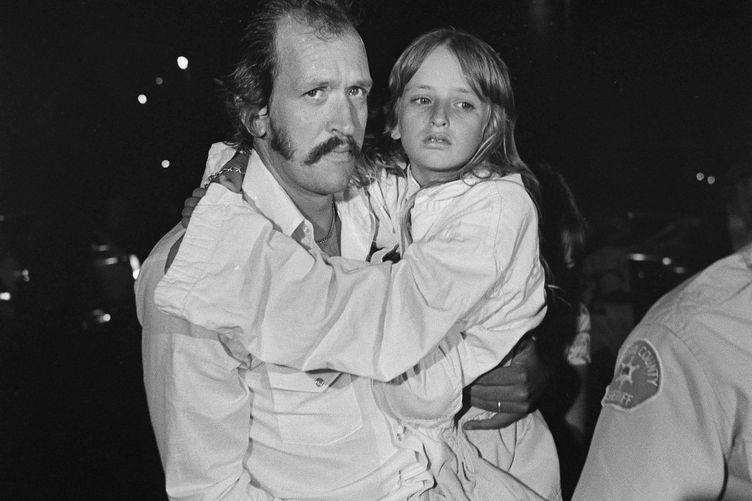 Dans cette photo d'archive du 17 juillet 1976, Darla Sue Daniels, 10 ans, est portée par son père après son sauvetage.
